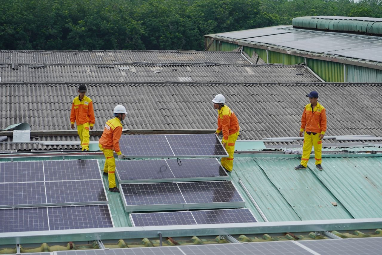 services-02 Workers installing solar panels on a roof for sustainable energy solutions.