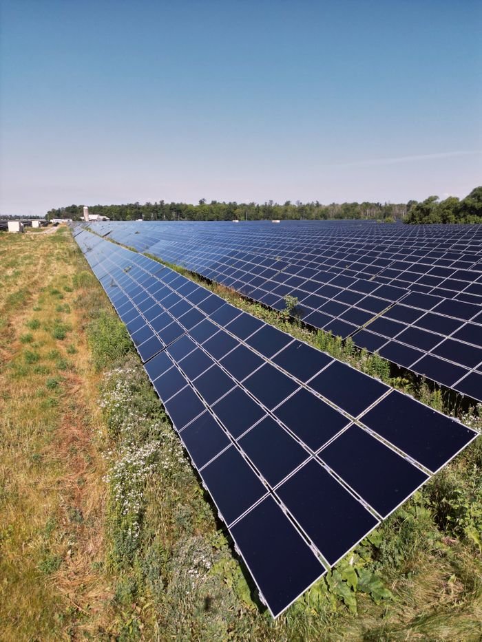 Mastering the First Impression: Your intriguing post title goes here Wide view of a solar panel farm under a clear blue sky in Mississippi Mills, ON, promoting renewable energy.